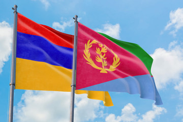 Fototapeta na wymiar Eritrea and Armenia flags waving in the wind against white cloudy blue sky together. Diplomacy concept, international relations.