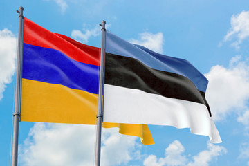 Estonia and Armenia flags waving in the wind against white cloudy blue sky together. Diplomacy concept, international relations.