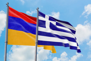 Greece and Armenia flags waving in the wind against white cloudy blue sky together. Diplomacy concept, international relations.