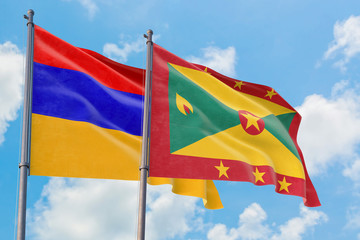Grenada and Armenia flags waving in the wind against white cloudy blue sky together. Diplomacy concept, international relations.
