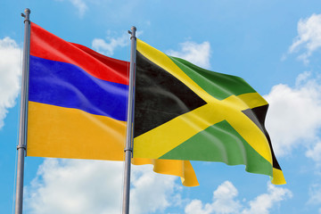 Jamaica and Armenia flags waving in the wind against white cloudy blue sky together. Diplomacy concept, international relations.
