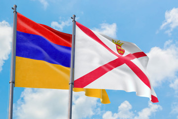 Jersey and Armenia flags waving in the wind against white cloudy blue sky together. Diplomacy concept, international relations.