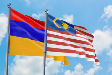 Malaysia and Armenia flags waving in the wind against white cloudy blue sky together. Diplomacy concept, international relations.