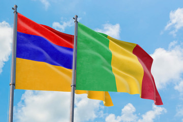 Mali and Armenia flags waving in the wind against white cloudy blue sky together. Diplomacy concept, international relations.