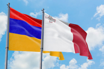 Malta and Armenia flags waving in the wind against white cloudy blue sky together. Diplomacy concept, international relations.