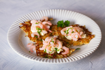Potato cakes with topping: cream cheese and shrimps. Vegetable fritters, latkes, draniki. Vegetable pancakes