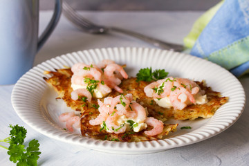 Potato cakes with topping: cream cheese and shrimps. Vegetable fritters, latkes, draniki. Vegetable pancakes