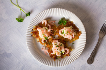 Potato cakes with topping: cream cheese and shrimps. Vegetable fritters, latkes, draniki. Vegetable pancakes. View from above, top view