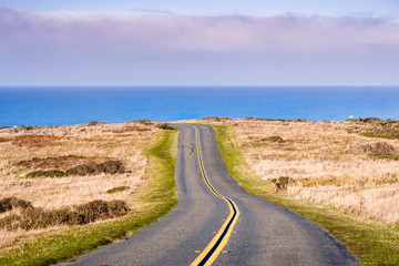Winding road on the Pacific Ocean coastline on a clear sunny day, Point Reyes National Seashore, California