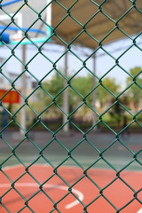 Naklejka premium outdoor basketball court behind a metal fence vertical composition