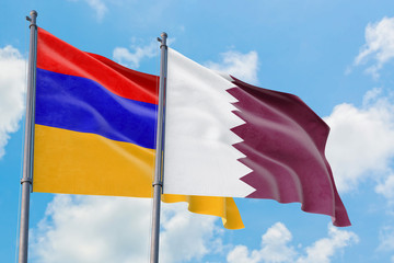 Qatar and Armenia flags waving in the wind against white cloudy blue sky together. Diplomacy concept, international relations.