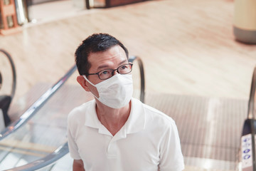 Middle aged Asian man wearing glasses and medical face mask,  Wuhan coronavirus outbreak, air pollution and health , social distanceconcept