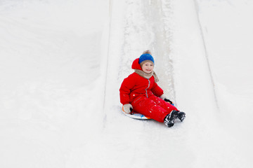 Fototapeta na wymiar Child slide downhill an ice hill