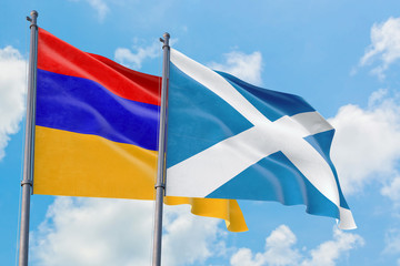 Scotland and Armenia flags waving in the wind against white cloudy blue sky together. Diplomacy concept, international relations.