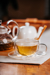 Cup of hot tea with rock sugar, dry leaves served in thermo glass cup
