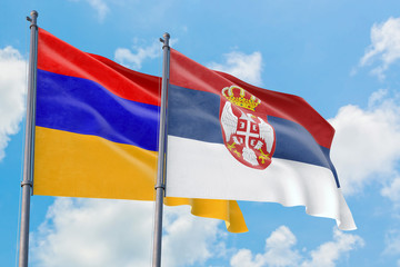 Serbia and Armenia flags waving in the wind against white cloudy blue sky together. Diplomacy concept, international relations.
