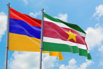 Suriname and Armenia flags waving in the wind against white cloudy blue sky together. Diplomacy concept, international relations.