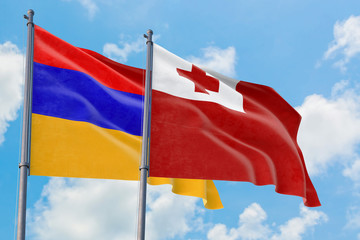 Tonga and Armenia flags waving in the wind against white cloudy blue sky together. Diplomacy concept, international relations.