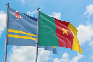 Cameroon and Aruba flags waving in the wind against white cloudy blue sky together. Diplomacy concept, international relations.