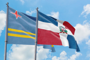 Dominican Republic and Aruba flags waving in the wind against white cloudy blue sky together. Diplomacy concept, international relations.