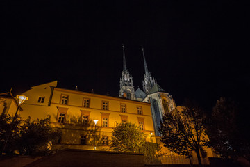 Brno Cathedral of saints peter and paul, seen from the bottow of Petro Hill, at night, surrounded by darkness. Also called katedrala svateho petra a pavla, it is a major landmark of the city of Brno