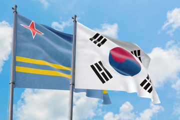 South Korea and Aruba flags waving in the wind against white cloudy blue sky together. Diplomacy concept, international relations.