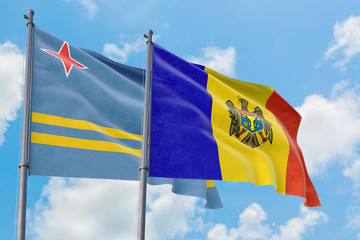 Moldova and Aruba flags waving in the wind against white cloudy blue sky together. Diplomacy concept, international relations.