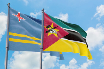 Mozambique and Aruba flags waving in the wind against white cloudy blue sky together. Diplomacy concept, international relations.