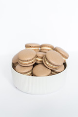 Coffe macaron in a white plate on a white isolated background