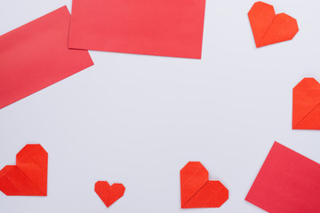 The red paper heart shapes and envelope over the white background. Greeting cards, Love and Valentines day concept. Flat lay, top view, copy space.