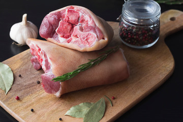 raw pork knuckle with spices on a cutting board