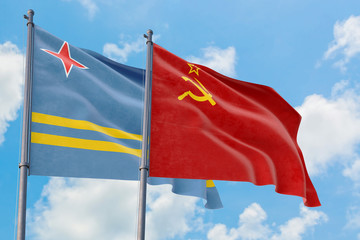Soviet Union and Aruba flags waving in the wind against white cloudy blue sky together. Diplomacy concept, international relations.