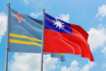 Fototapeta na wymiar Taiwan and Aruba flags waving in the wind against white cloudy blue sky together. Diplomacy concept, international relations.