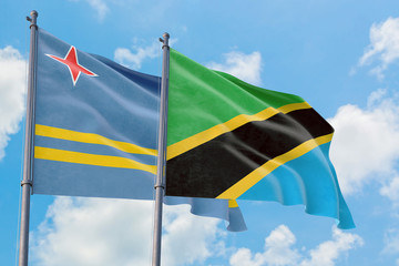 Tanzania and Aruba flags waving in the wind against white cloudy blue sky together. Diplomacy concept, international relations.