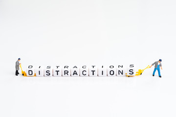 Miniature people man pulling forklift with cube small block building the word Distractions on solid...