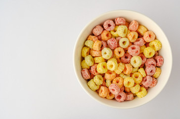 Cereal flakes in bowl with copy space,Breakfast concept.Food with delicious fruity taste and fruity colours.It's made with maize,wheat,and barley.topview and copy space.white background