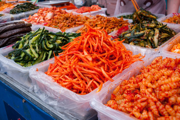 A variety of salads in trays on the counter at the food market in China, street food in the summer