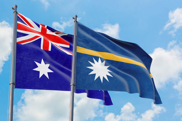 Nauru and Australia flags waving in the wind against white cloudy blue sky together. Diplomacy...