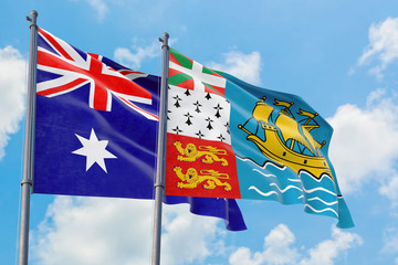 Saint Pierre And Miquelon and Australia flags waving in the wind against white cloudy blue sky together. Diplomacy concept, international relations.