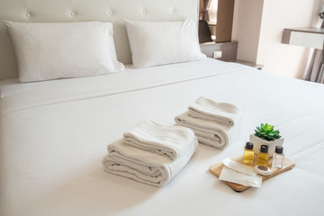 Set of hotel amenities (such as towels, shampoo, soap etc) on the bed. Hotel amenities is something...