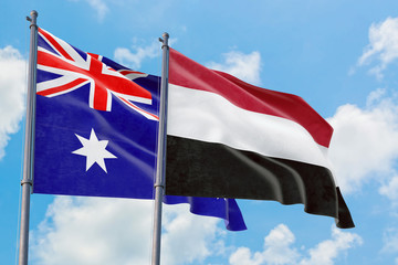 Yemen and Australia flags waving in the wind against white cloudy blue sky together. Diplomacy concept, international relations.