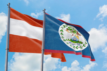 Belize and Austria flags waving in the wind against white cloudy blue sky together. Diplomacy...