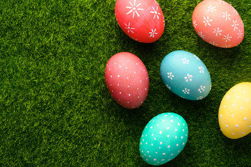 Easter eggs colored on green grass. Congratulations on Easter. Horizontal frame.