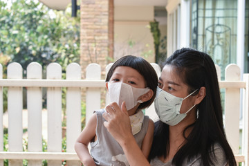 Mother and daughter wearing pm 2.5 face mask to protect against viruses and pollution