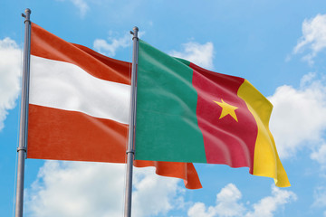 Cameroon and Austria flags waving in the wind against white cloudy blue sky together. Diplomacy concept, international relations.