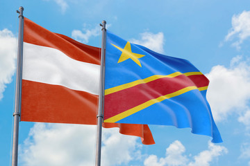 Congo and Austria flags waving in the wind against white cloudy blue sky together. Diplomacy concept, international relations.