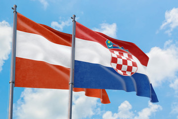 Croatia and Austria flags waving in the wind against white cloudy blue sky together. Diplomacy concept, international relations.