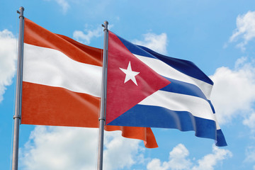 Cuba and Austria flags waving in the wind against white cloudy blue sky together. Diplomacy concept, international relations.