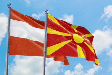 Macedonia and Austria flags waving in the wind against white cloudy blue sky together. Diplomacy concept, international relations.