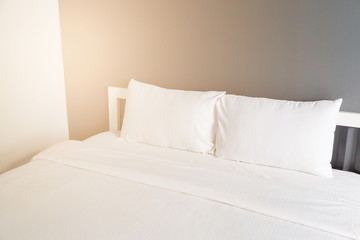 Two white pillow on bed and blanket